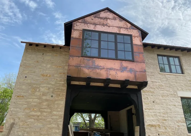 Copper metal panel facade on a stone building for Skylight Installation in Grinnell
